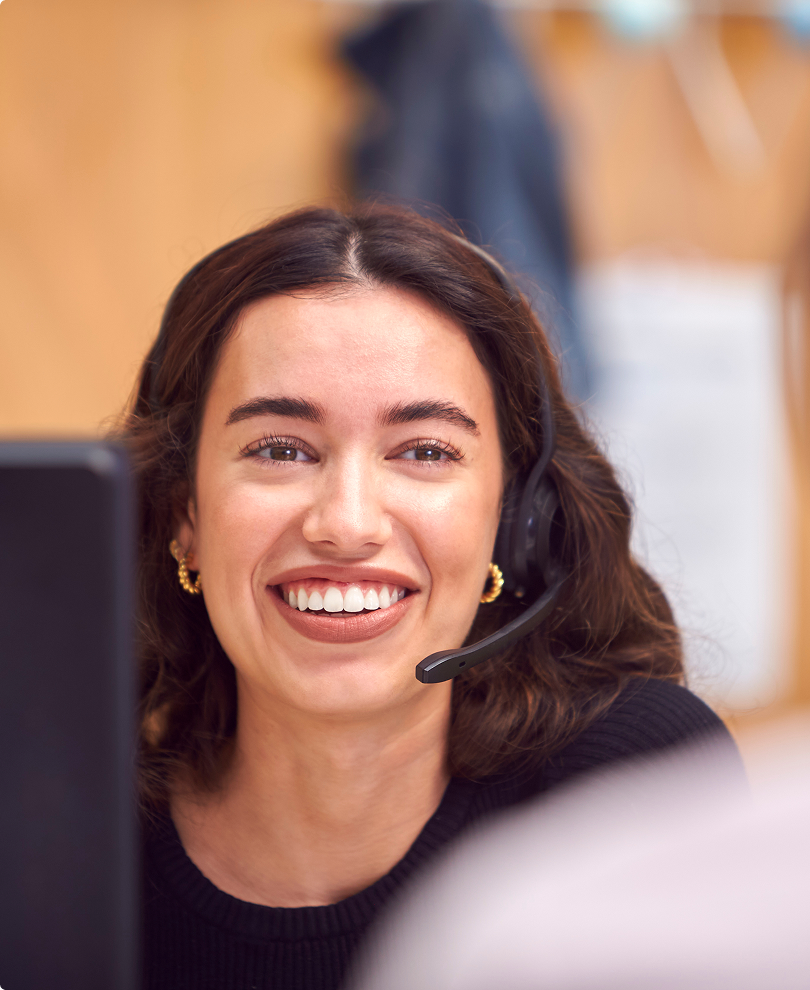 Smiling young female customer support representative wearing a headset