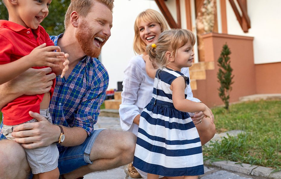 Happy smiling family of four spending quality time together outside their home