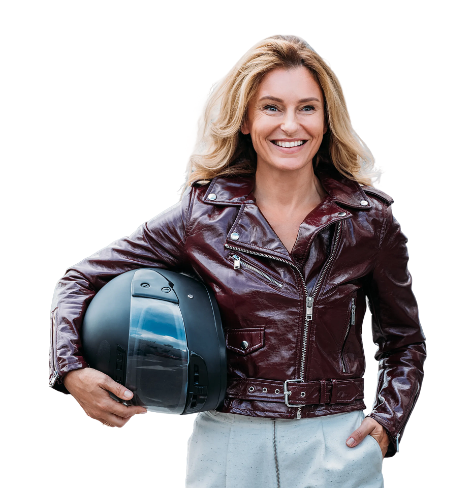Smiling woman with blonde hair wearing a brown leather jacket and holding a motorcycle helmet
