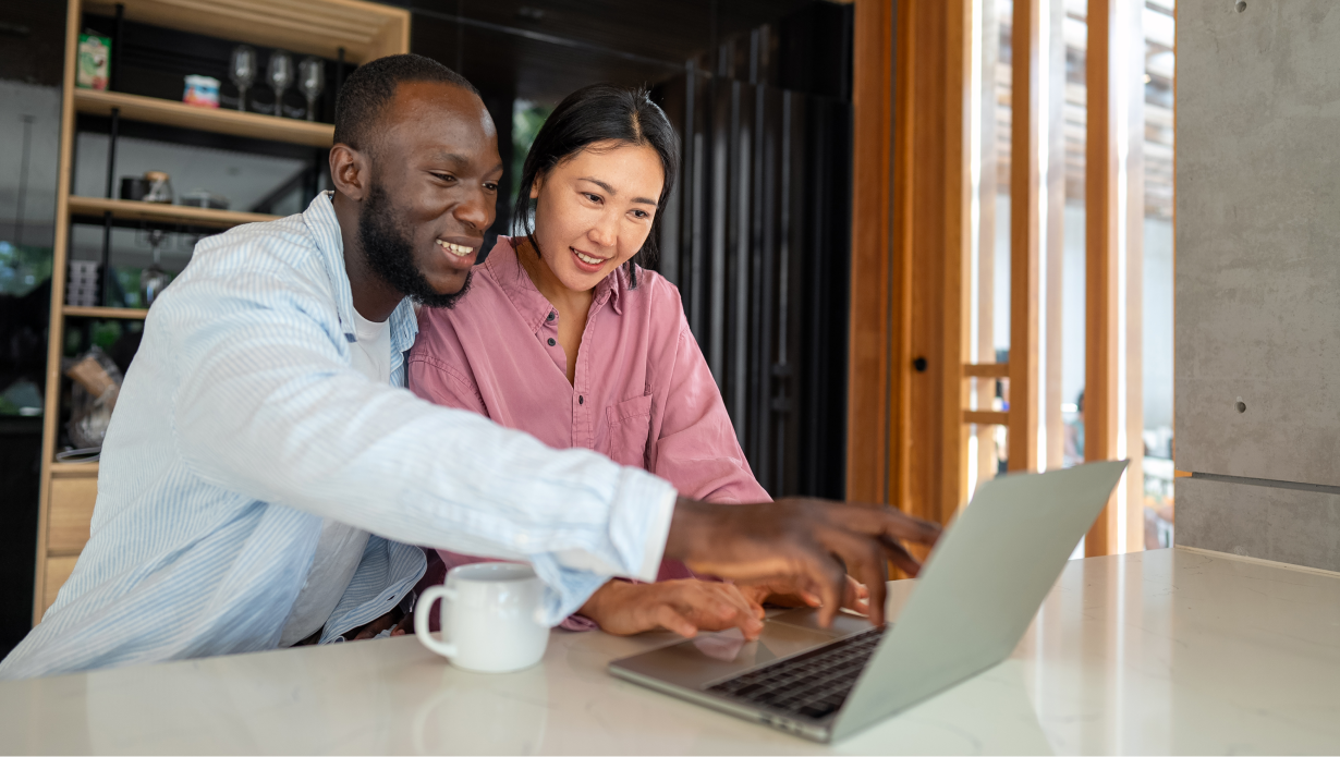Happy diverse multiethnic couple working together using laptop